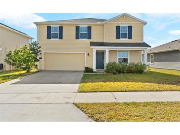 Charming two-story home featuring a two-car garage, well-maintained lawn, and inviting front porch at 740 Simone Ct, Haines City, FL 33844