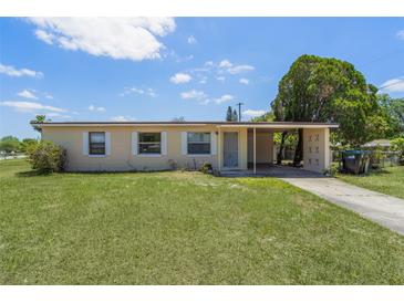 Charming single-story home featuring a covered carport and a well-maintained front lawn at 7700 Grevillea Dr, Orlando, FL 32822
