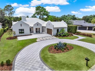 Stunning home featuring a circular driveway, elegant landscaping, and a three-car garage at 9364 Thurloe Pl, Orlando, FL 32827
