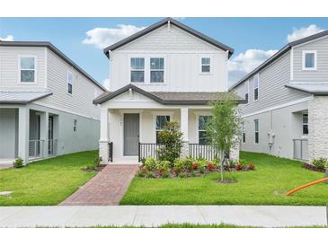 Charming two-story home features a well-manicured lawn, inviting front porch and lovely landscaping at 11941 Bracco St, Winter Garden, FL 34787