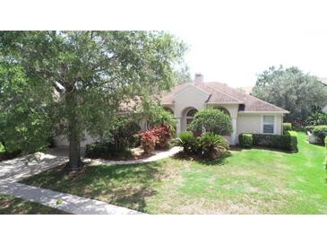 Well-manicured lawn and mature landscaping enhance this charming single-story home at 13250 Meergate Cir, Orlando, FL 32837
