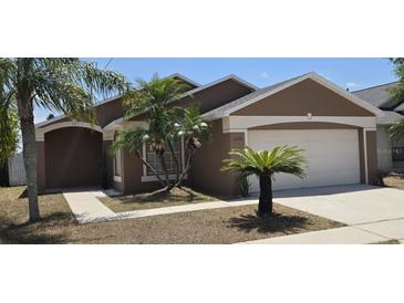 Charming single-story home with a manicured lawn and tropical landscaping for a welcoming curb appeal at 159 Piccolo Way, Davenport, FL 33896