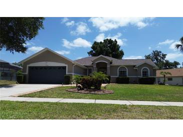 Charming single-story home featuring a well-manicured lawn and attached two-car garage at 15910 Mercott Ct, Clermont, FL 34714