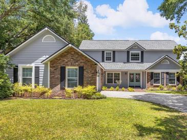 Charming two-story home featuring a manicured lawn, brick accents, and a welcoming front entrance at 226 Ringwood Dr, Winter Springs, FL 32708