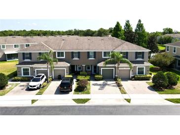 Charming townhome exterior featuring a brick driveway, tidy landscaping, and a neutral color palette at 2656 River Landing Dr, Sanford, FL 32771