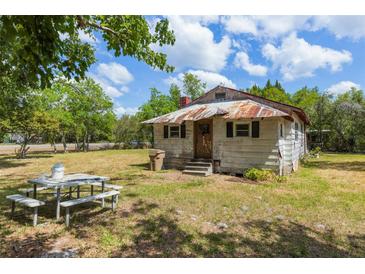 Exterior view of a single-story house with lawn and picnic table at 47730 State Road 19, Altoona, FL 32702