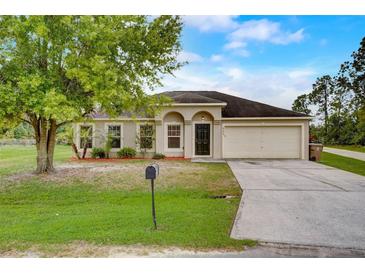 Charming single-story home with a well-manicured lawn and attached two-car garage at 927 Cambridge Ct, Kissimmee, FL 34758