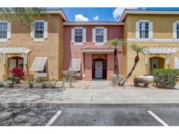 Inviting townhome featuring colorful exteriors, manicured landscaping, and a charming front entrance at 1041 Park Ridge Cir, Kissimmee, FL 34746