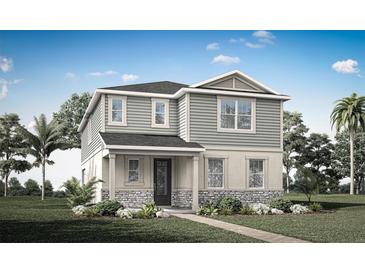 Charming two-story home featuring stone accents, gray siding, a well-manicured lawn, and a welcoming front porch at 13016 Pergola Ave, Orlando, FL 32832