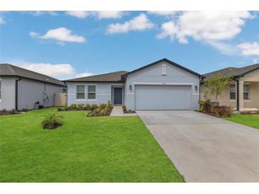 Charming one-story home featuring a well-manicured lawn and a two-car garage at 1312 Axel Graeson Ave, Kissimmee, FL 34744