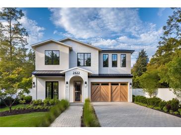 Stunning two-story home featuring a modern design, manicured lawn, and light stone driveway and walkway at 2422 Musselwhite Ave, Orlando, FL 32804