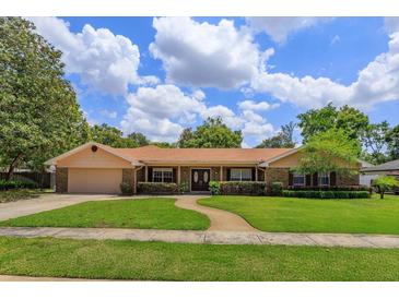 Charming single-story home featuring a well-manicured lawn and inviting front entrance at 413 Sandy Hill Dr, Longwood, FL 32779