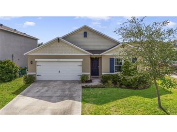 Charming single-story home featuring a well-maintained lawn, a two-car garage, and a welcoming front entrance at 415 Anne St, Deland, FL 32724