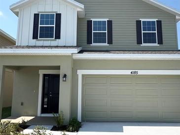 Two-story home featuring a two-car garage and black shutters on the windows, with neutral colored paint at 4185 Sagefield Dr, St Cloud, FL 34773