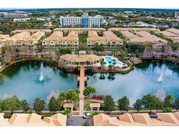 Beautiful aerial view of community pool, lake with fountain, and well-maintained grounds, surrounded by townhomes and buildings at 724 Greybull Run, Lake Mary, FL 32746