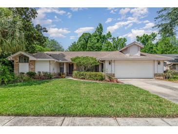 Charming single-story home featuring a well-manicured lawn and a two-car garage at 1100 Oday Dr, Winter Springs, FL 32708
