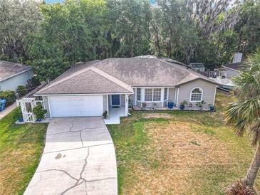 Charming single-story home featuring a well-manicured lawn, a two-car garage, and beautiful landscaping at 185 Poinciana Ln, Deltona, FL 32738
