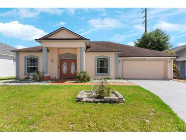 Charming single-story home with landscaped front yard, columns, and a two-car garage at 235 Hollingshead Loop, Davenport, FL 33896