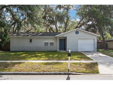 Charming single-story home with well-maintained lawn, blue door, and a one car garage at 2935 Arcata Ln, Orlando, FL 32817