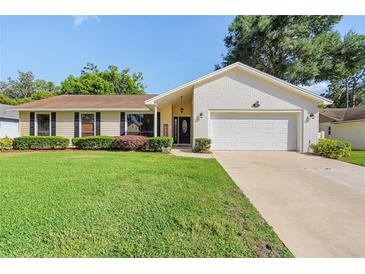 Charming single-story home featuring a manicured lawn and an attached two-car garage at 307 Coble Dr, Longwood, FL 32779