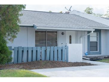 Charming single-story home with a gray roof and a small, fenced front yard at 3154 Stonecastle Rd, Orlando, FL 32822