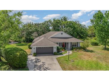 Charming single-story home featuring a well-maintained lawn, lush landscaping, and a two-car attached garage at 5494 Glen Oak Pl, Sanford, FL 32771