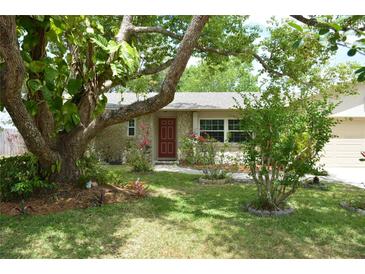 Charming single-story home featuring a stone facade, mature trees, and a well-manicured lawn at 622 Alton Rd, Winter Springs, FL 32708