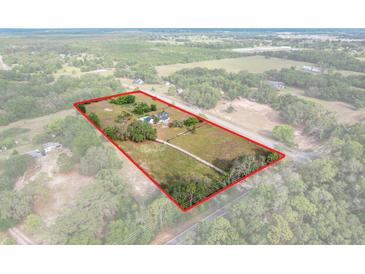 Expansive aerial view of property with red outline, showcasing the home, pool, and surrounding acreage at 6803 Round Lake Rd, Mount Dora, FL 32757