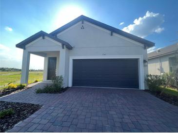 Charming single-story home featuring a two-car garage and inviting covered entry at 734 Via Como St, Poinciana, FL 34759