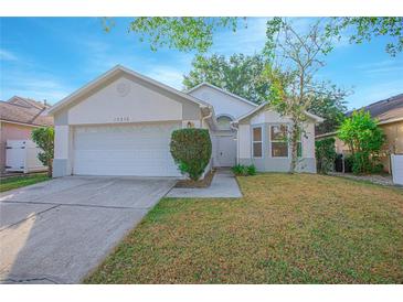 Charming single-story home with a two-car garage and well-maintained front yard at 13216 Wild Duck Ct, Orlando, FL 32828