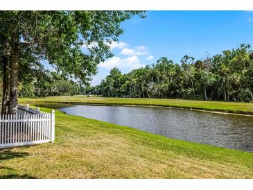 Scenic view of a lush golf course with a pond and mature trees, enhancing the property's appeal at 1527 Braewick St, Winter Springs, FL 32708