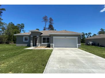 Charming single-story home featuring a well-manicured lawn and a two-car garage at 16927 Sw 25Th Terrace Rd, Ocala, FL 34473