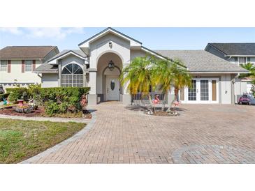 Charming home featuring lush landscaping, a brick driveway, and a covered entryway at 1994 Excalibur Dr, Orlando, FL 32822