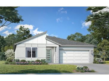 Charming single-story home featuring a modern design, complemented by a well-manicured lawn and colorful landscaping at 2013 Stone Wall Ct, Lake Hamilton, FL 33851