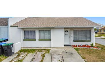 Charming home featuring white stucco, neutral roof, tidy front yard, and welcome decor at 2803 Charing Cross Way, Orlando, FL 32837