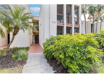 Inviting two-story condo featuring a well-manicured front yard with lush landscaping and a clearly marked address at 516 Orange Dr # 22, Altamonte Springs, FL 32701