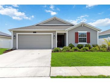 Charming single-story home featuring a neutral color scheme, attached garage, and manicured lawn at 5347 Travertine St, Mount Dora, FL 32757