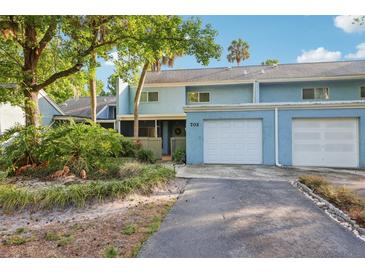 Charming two-story blue townhome with attached garage and mature landscaping at 702 Glasgow Ct, Winter Springs, FL 32708