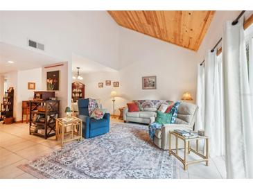 Bright living room features a wood ceiling, neutral walls, and a large rug at 702 Glasgow Ct, Winter Springs, FL 32708