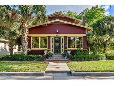 Charming home with a brick exterior, complemented by lush landscaping and a mature palm tree at 806 E Amelia St, Orlando, FL 32803