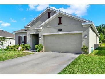 Charming single-story home featuring a two-car garage, well-maintained lawn, and neutral paint at 1880 Perch Hammock Loop, Groveland, FL 34736