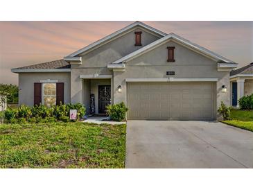 Charming single-story home featuring a two-car garage and inviting front yard landscaping at 1880 Perch Hammock Loop, Groveland, FL 34736