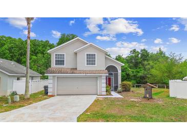 Charming two-story home featuring a well-manicured front yard and attached two-car garage at 232 Oxford Rd, Davenport, FL 33896