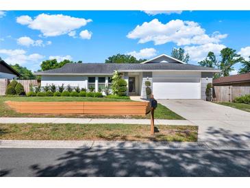 Charming single-story home boasts a well-manicured lawn, neutral paint scheme, and a two-car garage at 2811 Citron Dr, Longwood, FL 32779