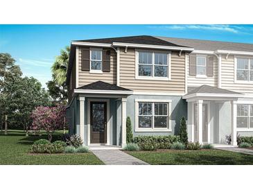 Charming two-story home with tan and blue siding, complemented by a well-maintained green lawn and landscaping at 2823 Camellia Flower St, Apopka, FL 32703