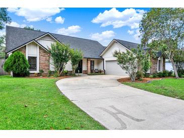 Charming single Gathering home featuring a brick facade, manicured lawn, and a long driveway at 370 Brushwood Ln, Winter Springs, FL 32708