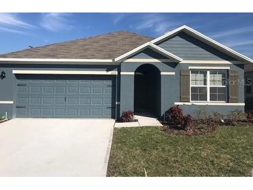 Charming single-Gathering home features a gray exterior, attached garage and manicured lawn at 5067 Tana Ter, St Cloud, FL 34772