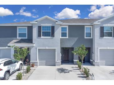 Charming townhome with a gray exterior, attached garage, and well-maintained landscaping at 5214 Dragonfly Dr, Wildwood, FL 34785