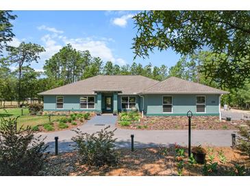 Charming single-story home featuring lovely landscaping and a welcoming driveway at 8660 Sw 137Th Ct, Dunnellon, FL 34432