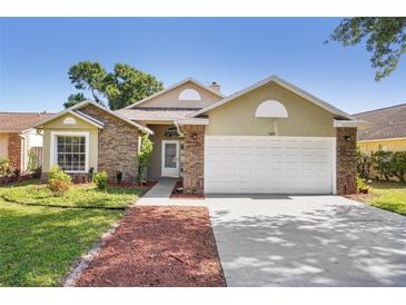 Charming single-Gathering home featuring a two-car garage, brick accents, and a well-maintained lawn at 143 Abbey Hollow Dr, Apopka, FL 32712
